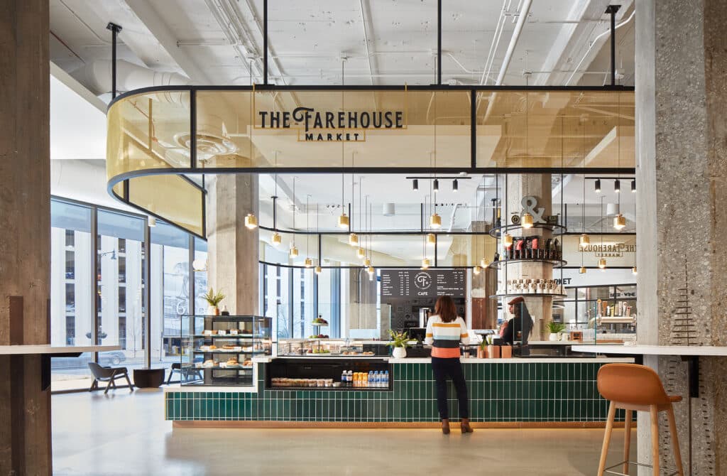 Customer stands at an elegant coffee bar with tall ceilings and columns