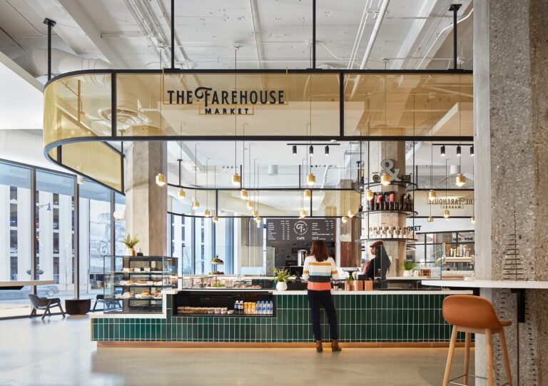 Customer stands at an elegant coffee bar with tall ceilings and columns