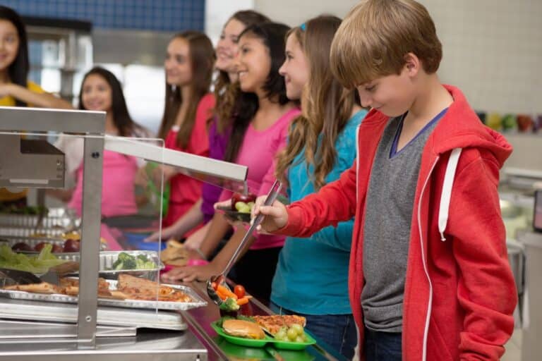 Students in lunch line serving fresh vegetables