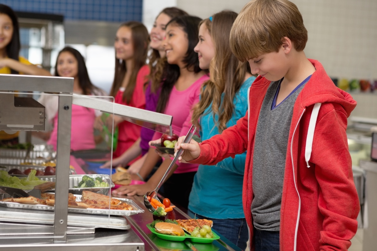 Students in lunch line serving fresh vegetables