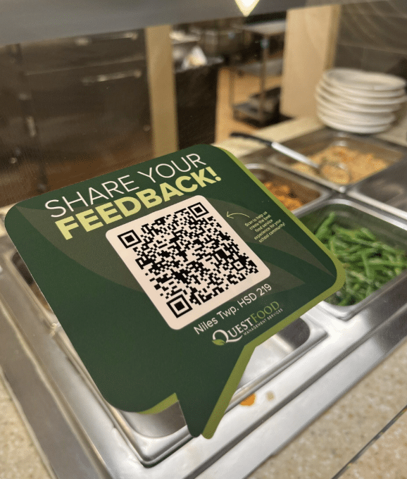 A QR code is prominently displayed on a food tray, ready for scanning to access menu or ordering information.