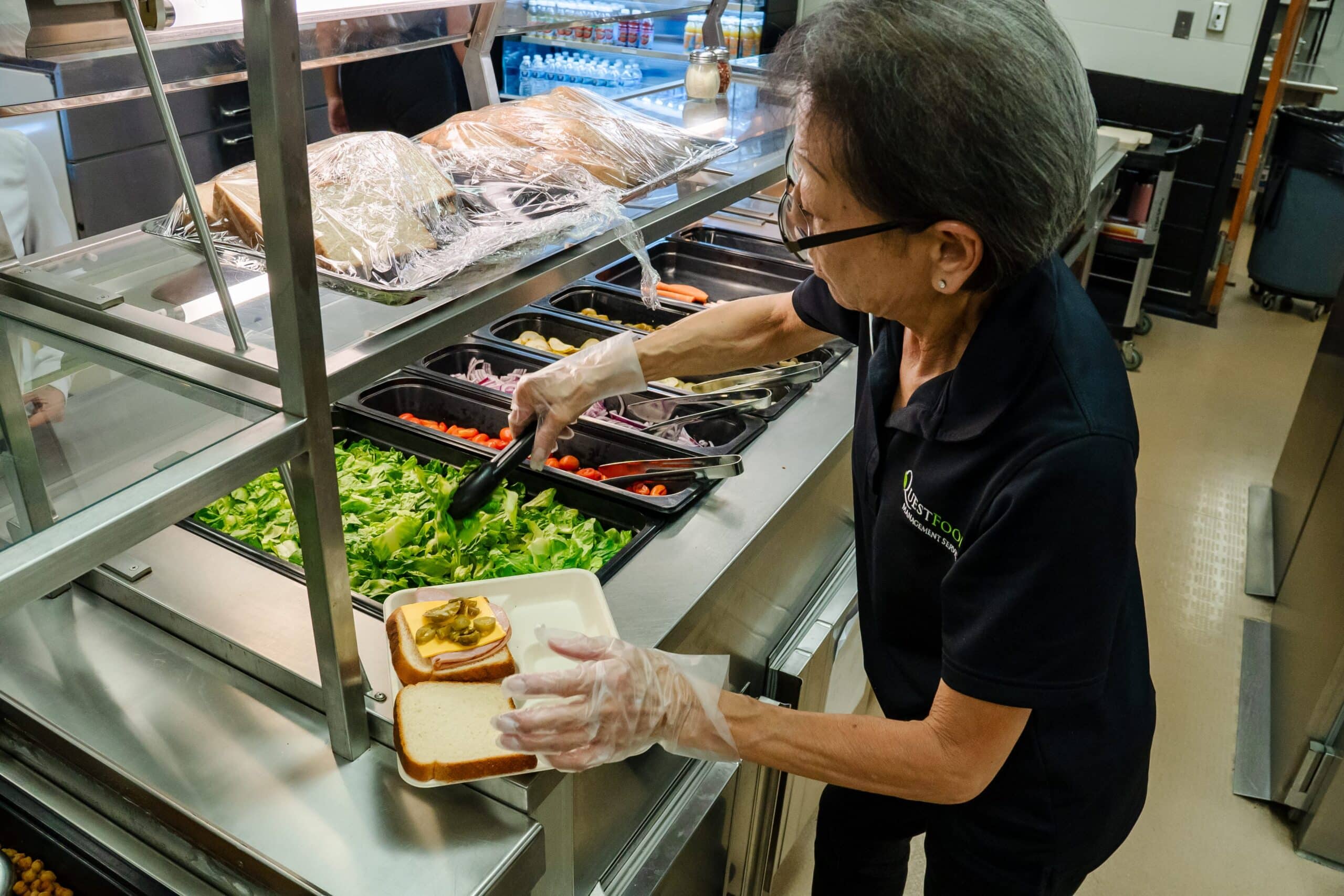 A lady preparing lunch at a buffet line